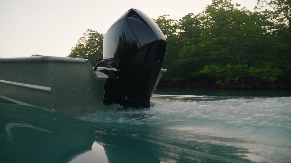 Electric outboard motor mounted on a small boat beside a wooden jetty